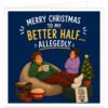Funny Husband Christmas card with navy blue background and text reading “Merry Christmas to My Better Half… Allegedly”. Humorous illustration shows a husband relaxing on a beanbag in tartan pyjama bottoms, holding a “King of Nothing” mug, while his wife stands with folded arms. Festive scene includes a Christmas tree, presents, popcorn, biscuits, remote control and “Do Not Disturb Husband in His Natural Habitat” sign.