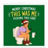 Funny Christmas card for him featuring a woman in a Santa hat sitting on the loo, looking at her phone, with the caption “Merry Christmas – This Was Me Picking This Card”.