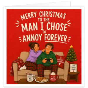Funny Husband Christmas card with bold red background and cream text reading “Merry Christmas to the Man I Chose to Annoy Forever”. Festive illustration shows a couple in tartan pyjamas relaxing on a sofa, with the wife playfully poking her husband’s cheek as he holds a games controller. Includes a decorated Christmas tree, mugs, biscuits, candy cane, cosy blanket and “Love Laugh Annoy” sign.