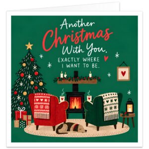 Romantic Christmas card for wife, girlfriend or partner with the message “Another Christmas With You. Exactly Where I Want to Be.” Cosy festive illustration features two armchairs beside a glowing log burner and decorated Christmas tree, with presents, steaming mugs, candles, lantern, holly, hearts and a sleeping dog. Warm green background with red festive details creates a loving Christmas scene for couples.