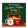 Funny romantic Christmas card for wife, girlfriend or partner featuring the text “My Favourite Christmas Tradition Is You”. Dark green design with a cosy glowing fireplace, festive garland, red berries and fairy lights. Two mugs of hot chocolate topped with cream and marshmallows sit in front, labelled “Him” and “Her” with heart motifs, alongside a sprig of holly.