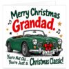 Funny Grandad Christmas card featuring the greeting "Merry Christmas Grandad" in bold red and green lettering. A vintage British racing green MG convertible sports car with tan interior, chrome details, festive holly wreath, red bow and "CLASSIC" number plate sits above the humorous message "You're Not Old... You're Just a Christmas Classic!" Decorative stars and musical notes complete the cheerful design on a white background. Ideal for Grandad, Grandpa or Grandfather who loves classic cars.