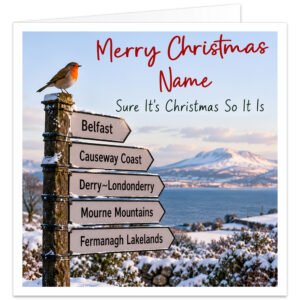 Personalised Northern Ireland Christmas card featuring the text "Merry Christmas [Name] – Sure It's Christmas So It Is". Festive snowy landscape with a colourful robin perched on a wooden signpost pointing towards Belfast, Causeway Coast, Derry\~Londonderry, Mourne Mountains and Fermanagh Lakelands. Red handwritten-style Christmas lettering and personalised name. Funny Northern Irish Christmas card for friends and family, printed on premium 300gsm matte white cardstock, 14.8 x 14.8 cm.